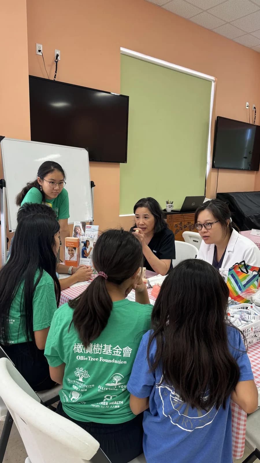 Healthcare professionals and volunteers discussing health information with community participants at a CCHPA health fair